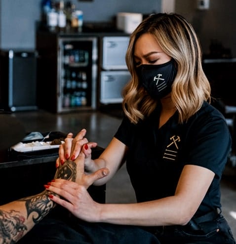 Artist performing hand massage at Hammer & Nails