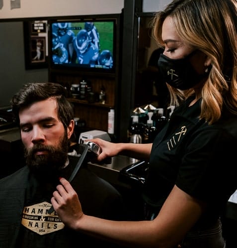 Artist trimming beard at Hammer & Nails