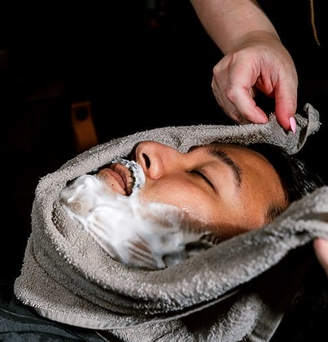 man using warm towel during shave