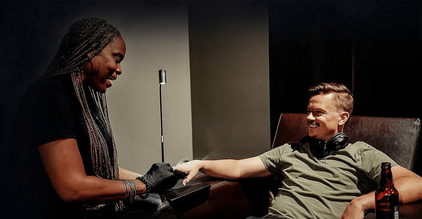 Grooming artist gives man seated in leather chair a pedicure