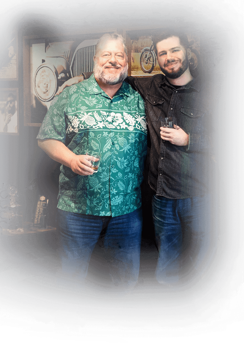Two men with drinks pose for photo at Hammer & Nails location